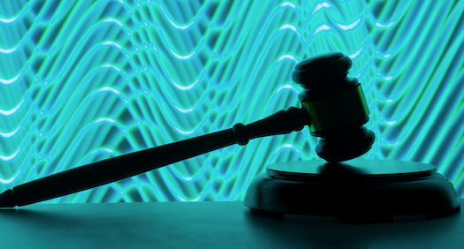 Vor einem Hintergrund aus wirbelnden blauen Linien lehnt ein brauner, als Silhouette dargestellter Hammer an einem Block.