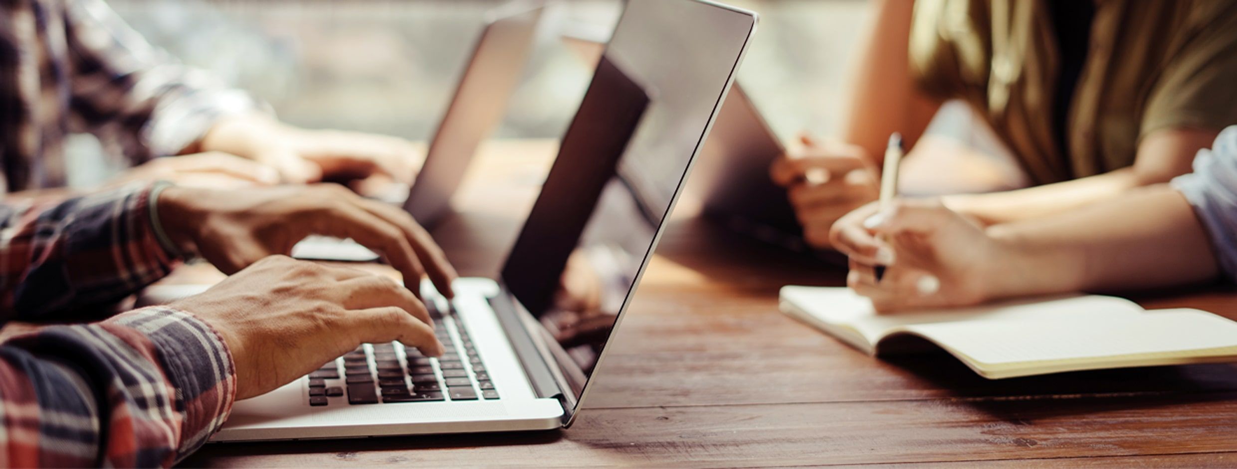 Archivbild. Mehrere Laptops, die auf einem Schreibtisch genutzt werden