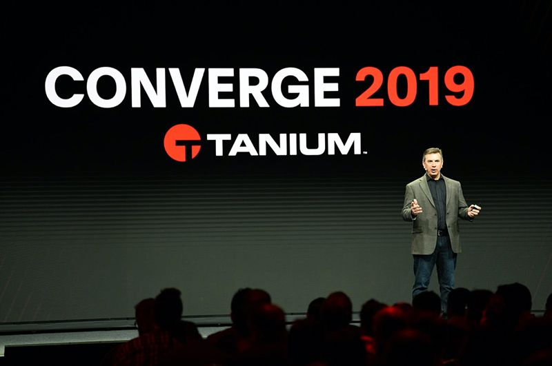 CONVERGE 2019 -Bühnenaufbau mit Lautsprecher und großen Bildschirmen, auf denen Tanium-Meldungen angezeigt werden