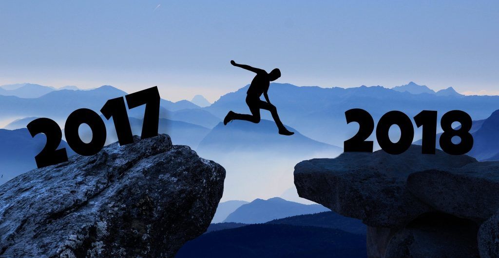 Silhouette einer Person, die zwischen den mit 2017 und 2018 gekennzeichneten Felsen hin und her springt