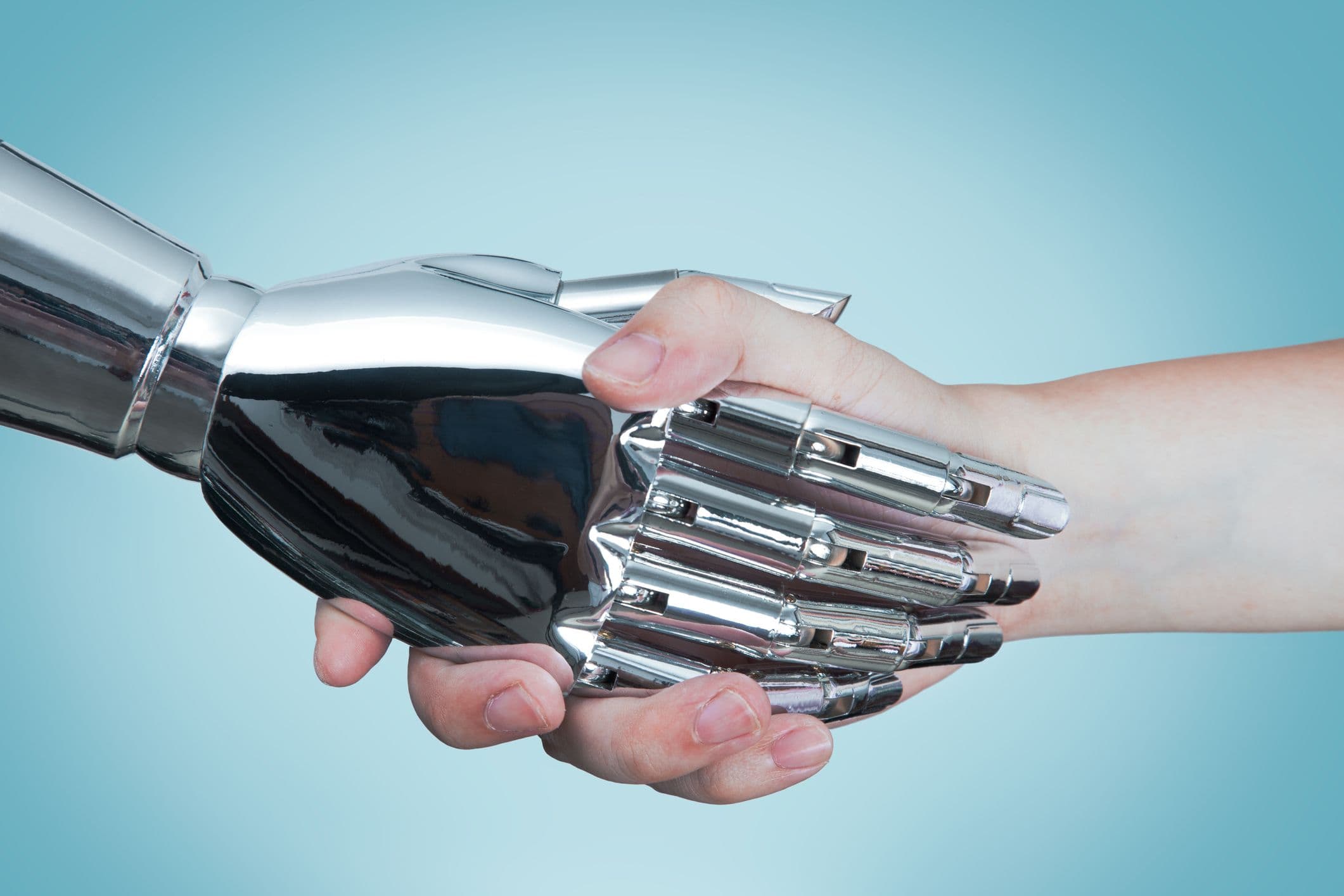 Eine Nahaufnahme eines Händedrucks zwischen einem KI-Roboter und einem Menschen.