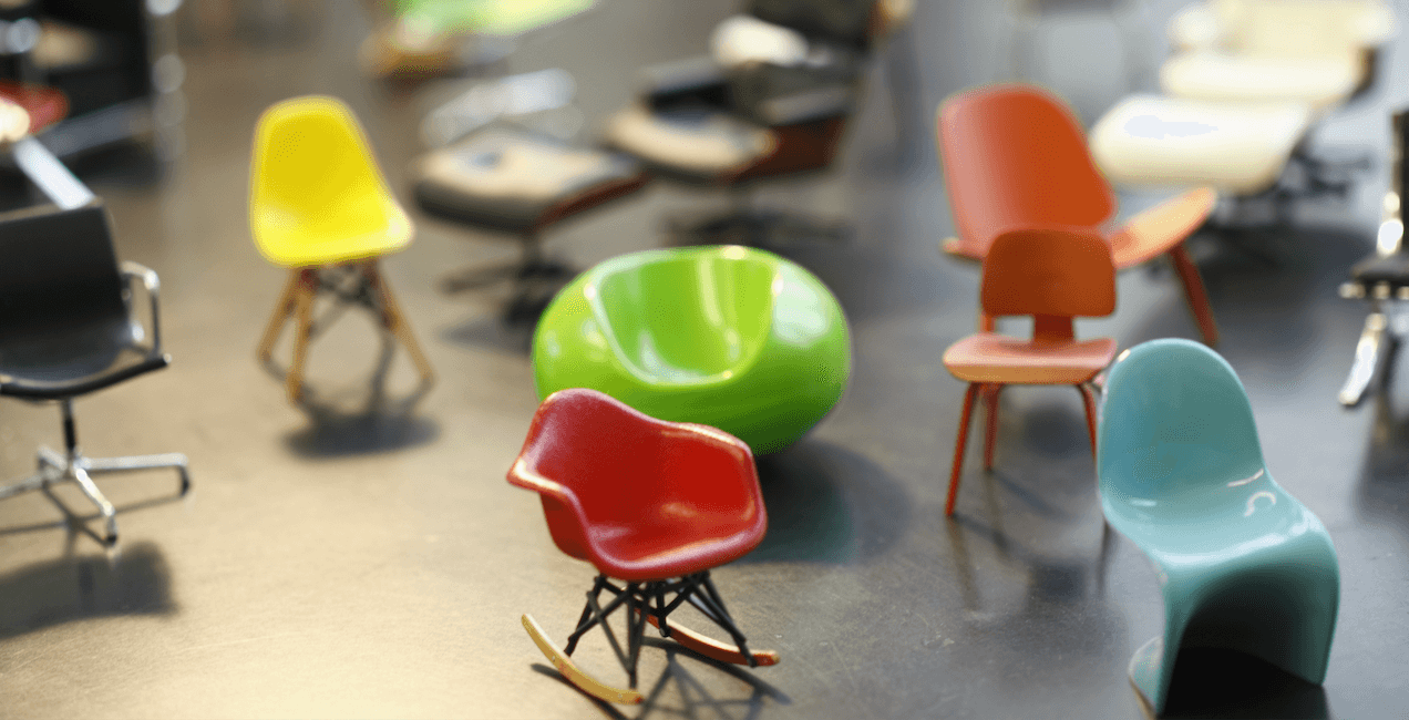 Eine Sammlung von Miniatur-Designerstühlen in geschwungenen Formen und leuchtenden Farben.